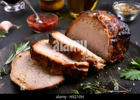 In Scheiben geschnitten Grillfleisch auf Holzbrett auf dunklem Hintergrund, Nahaufnahme Stockfoto