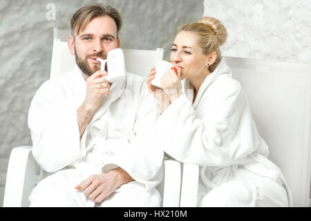 Paar, sitzen in der Salzkammer Mineralwasser trinken. Anwendung von Salz-Therapie im Spa Stockfoto