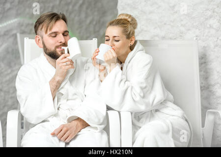 Paar, sitzen in der Salzkammer Mineralwasser trinken. Anwendung von Salz-Therapie im Spa Stockfoto