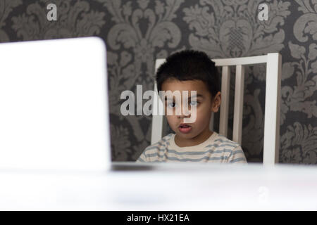 Kleiner Junge Zeichentrickfilme auf seinem Eltern-laptop Stockfoto