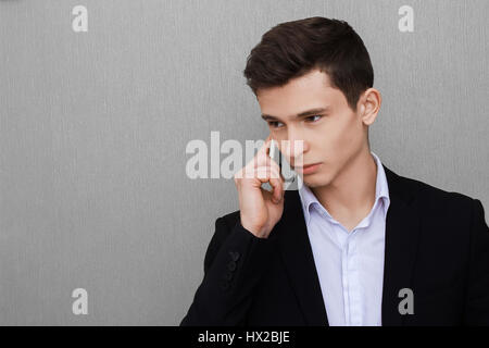 Closeup Portrait, hübscher junger Geschäftsmann, glücklicher Kerl, mit Weste, mit Handy, lächelnd, angenehmes Gespräch, isoliert grau schwarz hinterlegt. Menschliche Gefühle, Ausdruck Stockfoto
