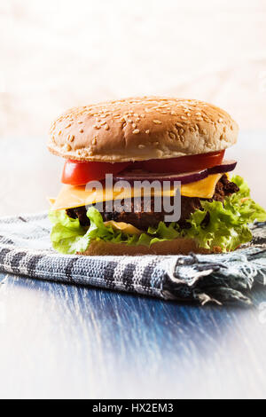 Hamburger auf Papier und blauer Tisch Stockfoto