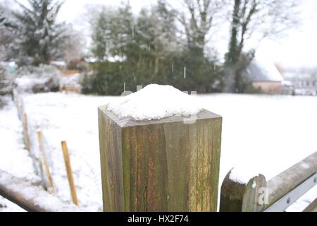 Schnee auf einem Zaunpfahl Stockfoto