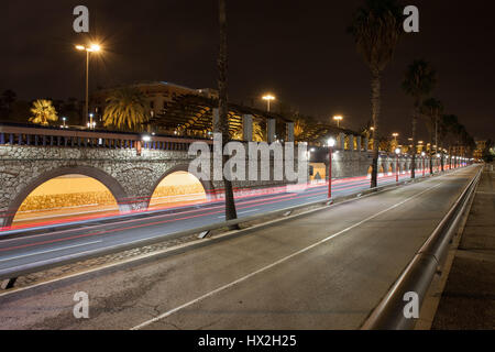 Spanien, Barcelona, Ronda Litoral Autobahn nachts mit Steg, Bögen der Allee Passeig de Colom, städtische Infrastruktur Stockfoto