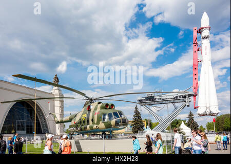 Moskau - 8. Mai 2016: Menschen in der Nähe von militärischen Transporthubschrauber Mil Mi-8T und Wostok-Rakete in WDNCh Park. Es war in der Sowjetzeit bauen Stockfoto