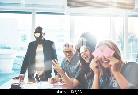 Fröhlich Business-Team von fünf jungen Menschen lustig posiert mit leeren Erinnerungen im Büro gemacht Stockfoto