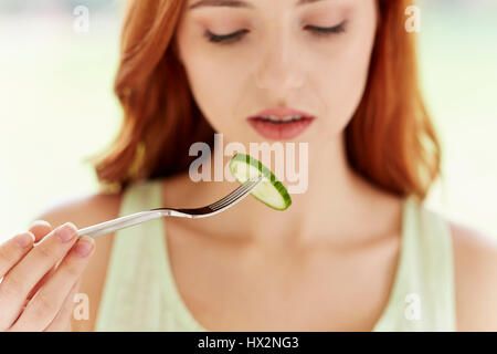 Frau, die eine Gurkenscheibe isst Stockfoto