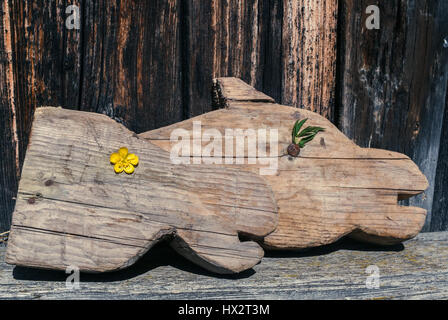 Retro-Bild. Zwei alte geschnitztes Holzpferd der Köpfe (Kinderspielzeug - Pferdekopf auf Stick) legen auf alten schäbigen Bank auf alten hölzernen Hintergrund. Stockfoto