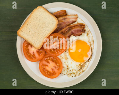 Authentische Flach bunte Englisches Frühstück, gebratenen Speck, Ei, Sunny Side Up, und gegrillten Tomaten Stockfoto
