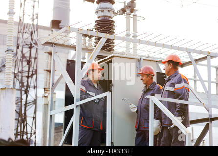 Elektrischen Arbeiter reparieren das Kraftwerk auf dem Hintergrund der Produktion Stockfoto