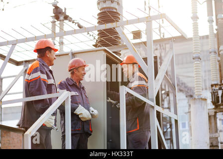 Elektrischen Arbeiter reparieren das Kraftwerk auf dem Hintergrund der Produktion Stockfoto