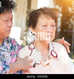 Reportageaufnahme der älteren Asiatinnen Chit Chat bei Outdoor-Park am Morgen. Stockfoto