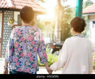 Offenen Schuß von hinten sehen asiatische ältere Frauen, die zu Fuß in der Outdoor-Park am Morgen. Stockfoto