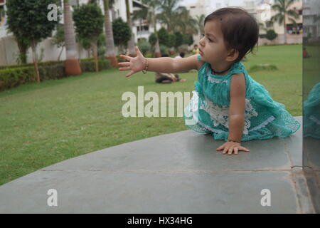 niedlichen indische Baby Fragen spielen im heimischen Garten irgendwo in Indien Stockfoto