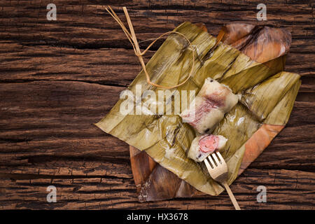 Khao Tom Matte - Thai Dessert - klebrigen Reis, Bananen und schwarzen Bohnen eingewickelt in Bananenblatt - Still-Leben hautnah auf hölzernen Hintergrund Stockfoto