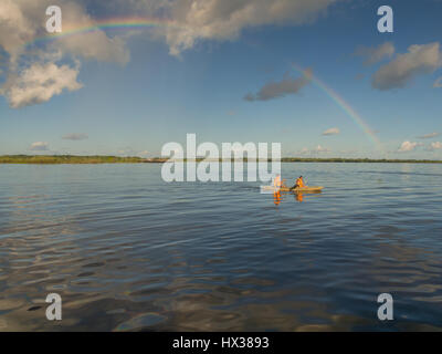 Iquitos, Peru - 16. Mai 2016: Regenbogen über Amazonas und Kajak mit den Kanuten. Stockfoto