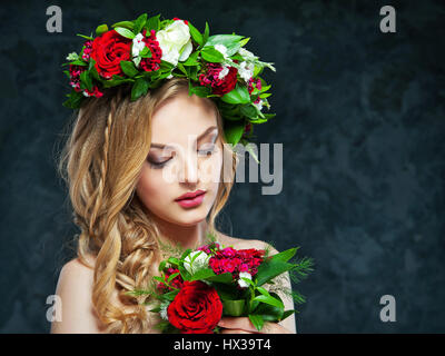 Porträt von einem schönen blonden Mädchen mit einer Komposition aus Blumen Stockfoto