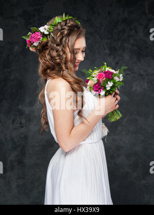 Porträt von einem schönen Brünette Mädchen mit einer Komposition aus Blumen Stockfoto