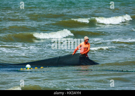 Filipino junge hilft eine große Seine net ans Ufer ziehen. Er ist Teil eines Fischerdorfes kooperativen, die Fische den Panay-Golf in der Nähe von BayBay Beach, Ro Stockfoto