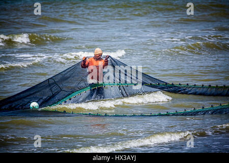 Ein junger Filipino Fischer arbeitet mit seinem Seine net im Surf in Küstennähe bei Baybay Beach, Roxas City, Insel Panay, Philippinen, Südostasien. Stockfoto