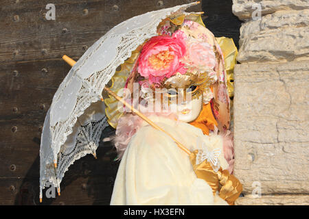 Eine Dame mit einer venezianischen Maske und Sonnenschirm außerhalb der Dogenpalast während des Karnevals in Venedig, Italien Stockfoto