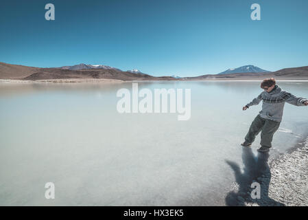 Touristen zu Fuß neben "Laguna Canapa', eine salzige See auf dem Weg zu den berühmten Uyuni Salz flach, unter das wichtigste Reiseziel in Bolivien. Stockfoto