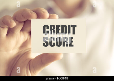 Closeup auf Geschäftsmann hielt eine Karte mit Text Kredit-SCORE, Firmen-Konzept-Image mit soft-Fokus-Hintergrund und Vintage-Ton Stockfoto