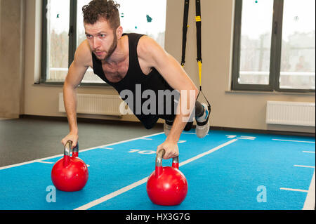 weiße lockige bärtigen sportlichen Mann mit Fitness Riemen im Fitness-Studio trainieren Stockfoto