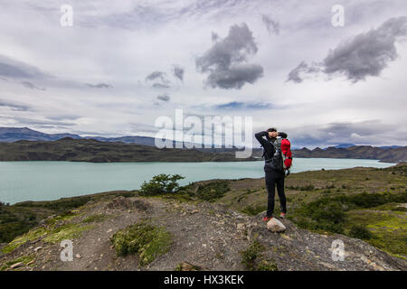 Mädchen mit Rucksack stehend auf dem Stein über dem See in Patagonien Stockfoto