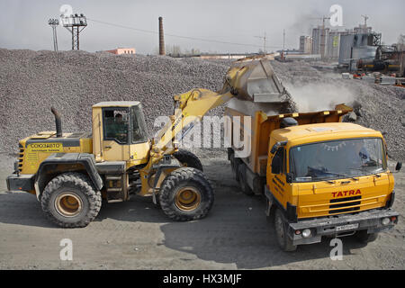 St. Petersburg, Russland - 27. April 2009: Baumaschinen und Maschinen, lädt ein Haufen Bau Kies, gelbe Bagger Schotter in o Stockfoto