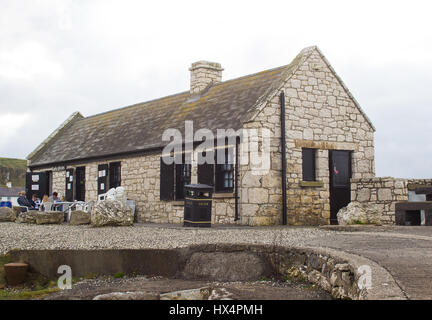 Am 12. März 2017 eine kleine Familie genießen Sie Kaffee im Shop und Besucher Zentrum am schönen Ballintoy Hafen an der nördlichen Küste des County Antrim in N Stockfoto