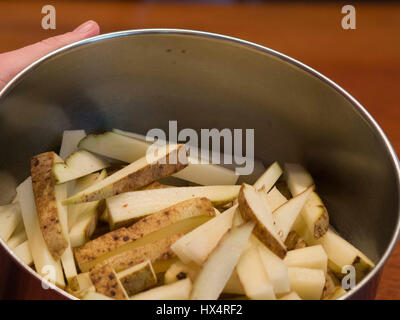 Kartoffel, die geschnitten worden ist, um hausgemachte Pommes frites in einer Metallschale machen. Stockfoto