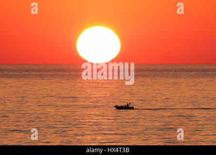 Ein kleines Fischerboot mit Sonnenuntergang über dem Mittelmeer in der Nähe von Paphos, Zypern, Südeuropa. Stockfoto