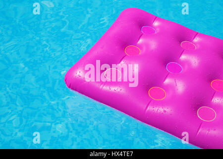 Rosa Luftmatratze auf ein Schwimmbad - Ferienkonzept tropischen Hintergrund Stockfoto