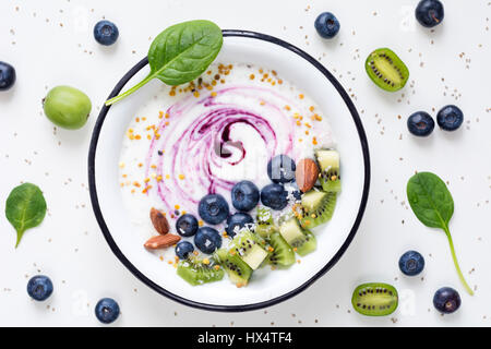 Smoothie-Schüssel mit Acai-Beere, Kiwi, Heidelbeeren, Mandeln, Kokosnuss, Bee Pollen und Baby Spinat auf weißem Hintergrund. Draufsicht der gesunden Entgiftung smoothy Stockfoto