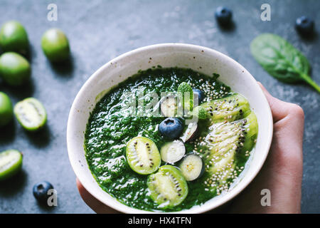 Hand, die Schüssel mit grünen Spinat Detox Smoothie. Detailansicht Stockfoto