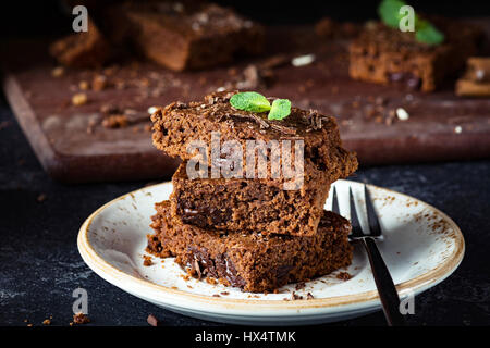 Brownies mit Schokolade verziert mit Minze auf einem Dessertteller, Nahaufnahme Stockfoto