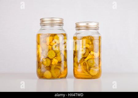 Gläser mit hausgemachtem Brot und Butter Pickles auf einer weißen Fläche. Konservendosen isoliert auf weißem Hintergrund. Stockfoto