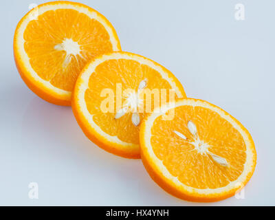 Drei Ringe geschnittenen saftige Reife Orange auf einem hellblauen Hintergrund. Stockfoto