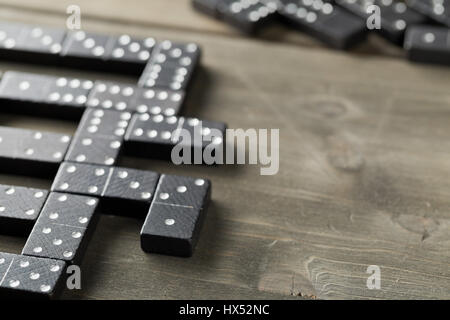 Spiel von Domino mit Domino-Steinen auf hölzernen Hintergrund; selektiven Fokus auf Domino-Stein vor Stockfoto