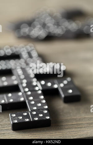 Spiel von Domino mit Domino-Steinen auf hölzernen Hintergrund; selektiven Fokus auf Domino-Stein vor Stockfoto