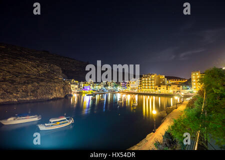 Xlendi, Gozo - schöne Luftaufnahme über die Bucht von Xlendi bei Nacht mit Restaurants, Boote und lebendiges Nachtleben auf der Insel Gozo Stockfoto