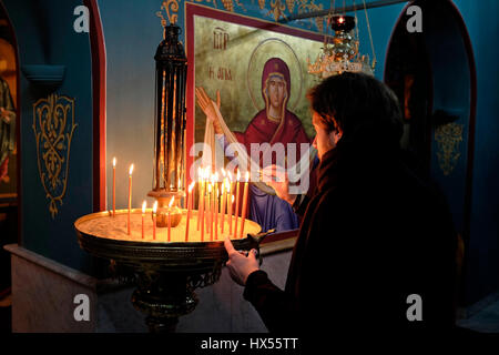 Ein christlich-orthodoxer Gläubiger zündet Kerzen in der Kirche des griechisch-orthodoxen Klosters an, bekannt als Gethsemane Metoxion, wo eine berühmte Ikone der heiligen Maria das ganze Jahr über stattfindet (außer in der Nacht vom 25. August, in der sie entlang einer Prozession bewegt wird, An das Grab der Maria auf der Slop des Ölbergs für die Woche der Feier der Himmelfahrt der Maria in den Himmel) befindet sich auf der Seite der Kirche des Heiligen Grabes im christlichen Viertel Altstadt Ost-Jerusalem Israel Stockfoto