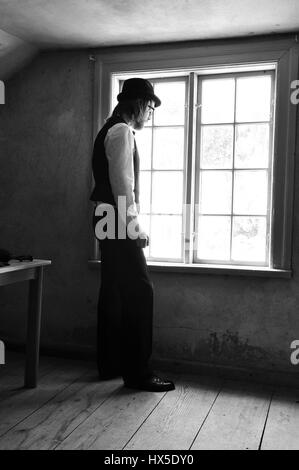 Elegante Jüngling Loooking aus dem Fenster. Stockfoto