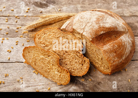 in Scheiben Roggenbrot mit trockenen Ohren auf einem Holztisch. Gesunde Ernährung Stockfoto