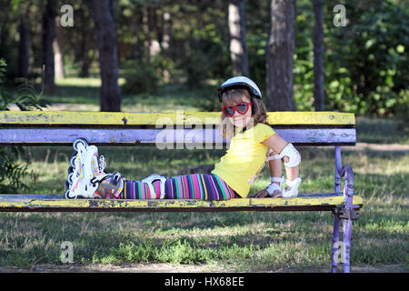 kleines Mädchen mit Rollschuhen im park Stockfoto