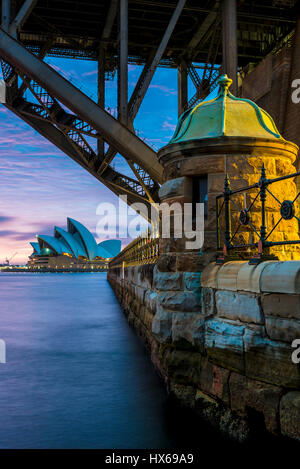 Sydney Opera House in der Morgendämmerung betrachtet unter der Sydney Harbour Bridge Stockfoto