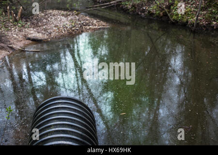 Schmutziges Wasser ergibt sich aus dem Rohr, die Verschmutzung des Flusses Stockfoto