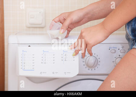 Nahaufnahme eines Mädchens Hand Waschmaschine einstellen. Stockfoto
