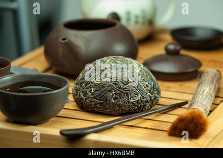 Shen puer chinesischen Tee tuo cha auf chaban (Tee Tabelle) whis Tee Zubehör in der traditionellen chinesischen Teezeremonie Stockfoto